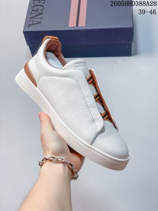 White and tan Zegna Tiziano low-top sneaker shown at an angle beside its box.