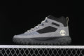Side view of a grey and black Timberland mid-cut lace-up sneaker.