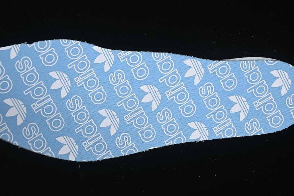 Blue insole fabric with repeating adidas Trefoil branding