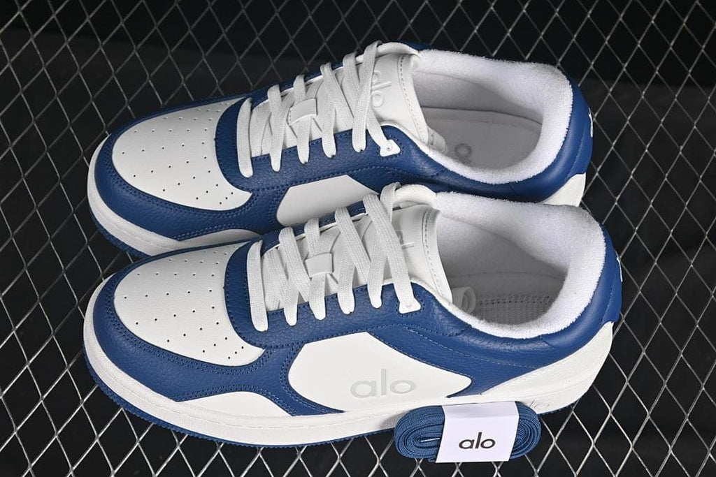 Pair of navy and white sneakers with spare navy laces