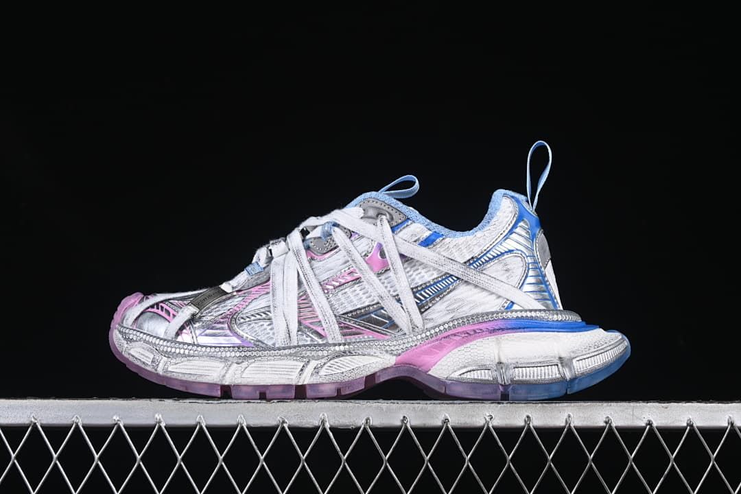 Side view of the white and silver-toned sneaker with pink and blue accents