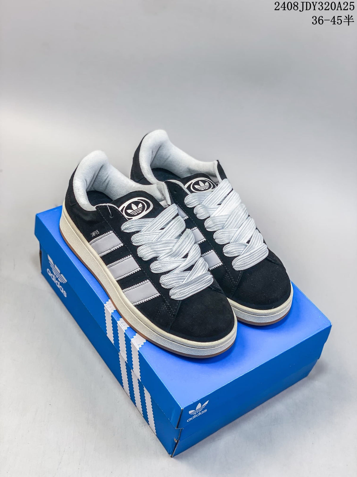 Pair of black Adidas Campus 00s sneakers with white stripes and laces, shown on a blue shoe box.