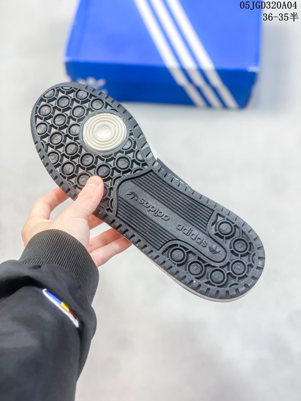 Close-up of the patterned outsole on a cream and black Forum 84 sneaker.