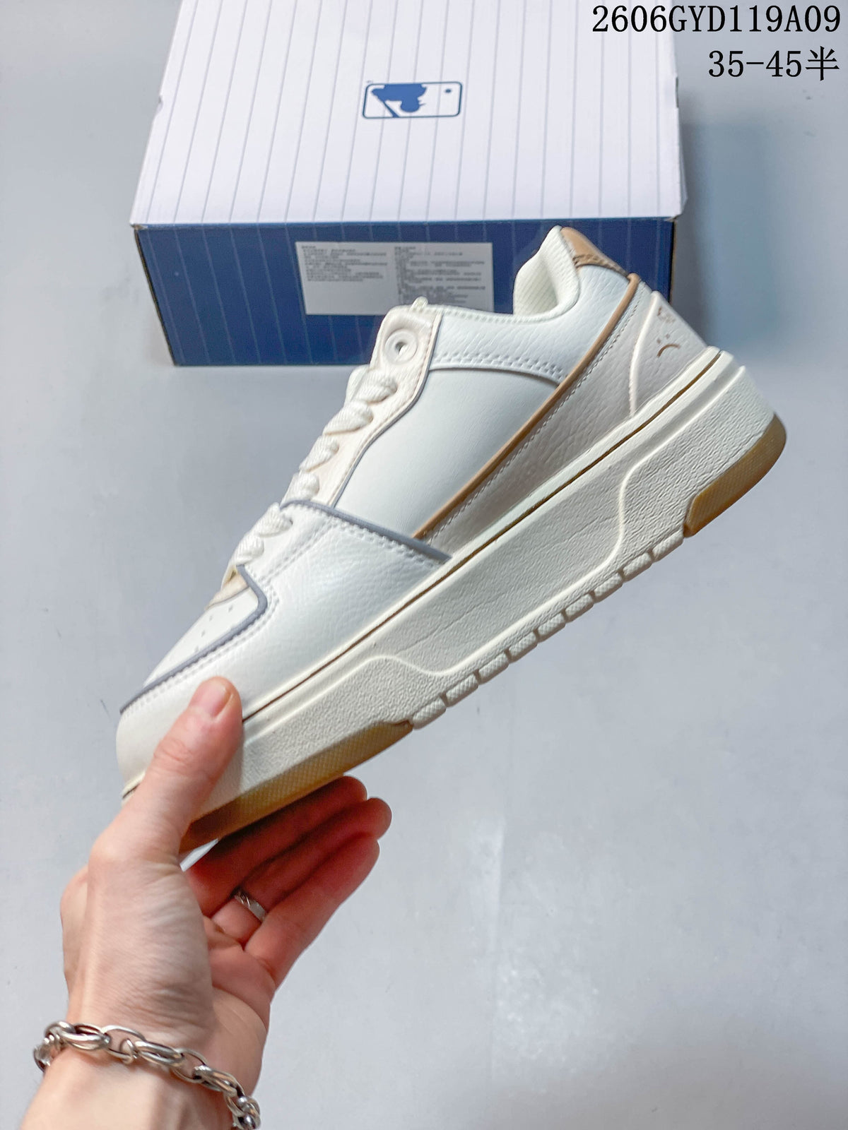 Side view of a white low-top sneaker with a chunky cream-colored sole