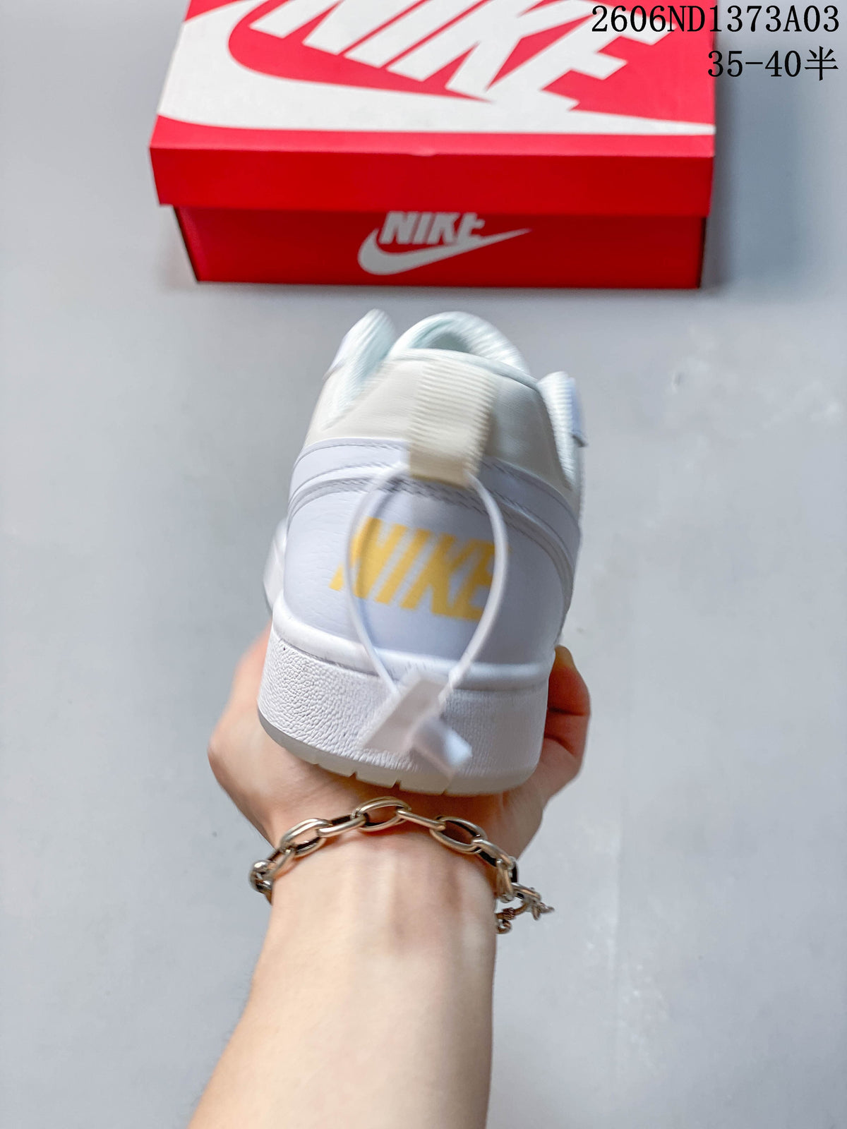 Rear view of the white sneaker with a yellow heel detail