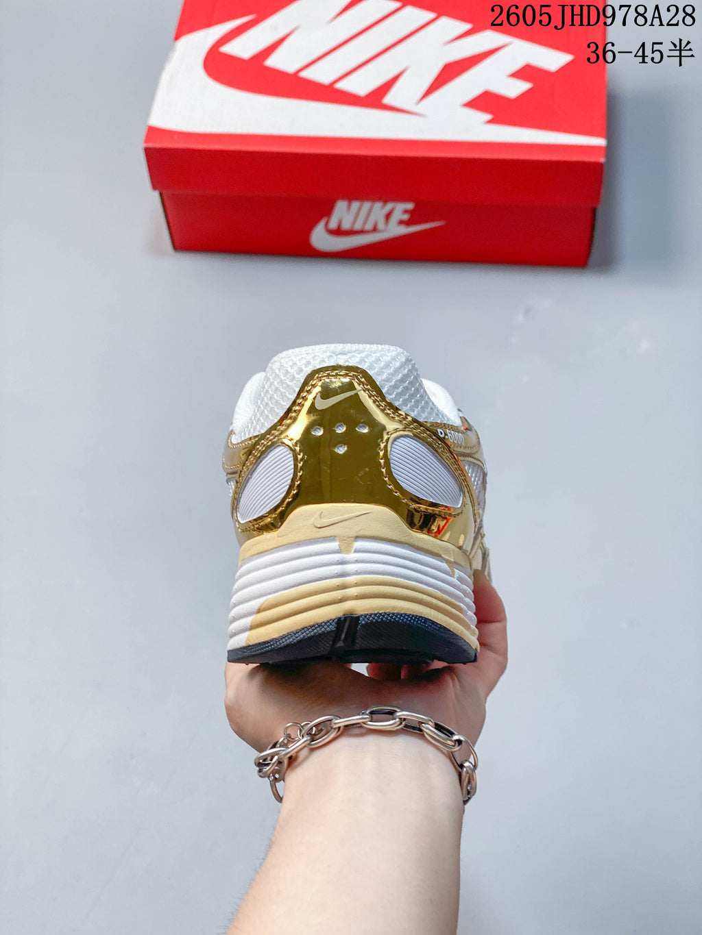Rear view of the white and gold-tone Nike Initiator shoe
