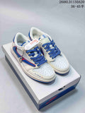 White low-top sneakers with blue and red accents, blue laces, and decorative side detailing.