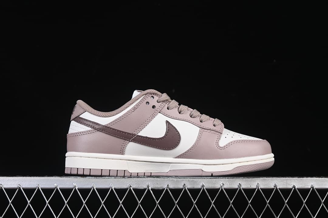 Side profile of a single pink and white low-top sneaker.