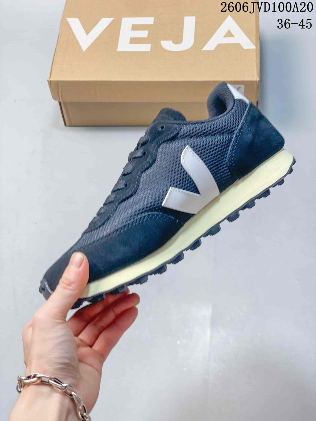 Side view of a navy Veja low sneaker with a white V-shaped logo and light-colored midsole.