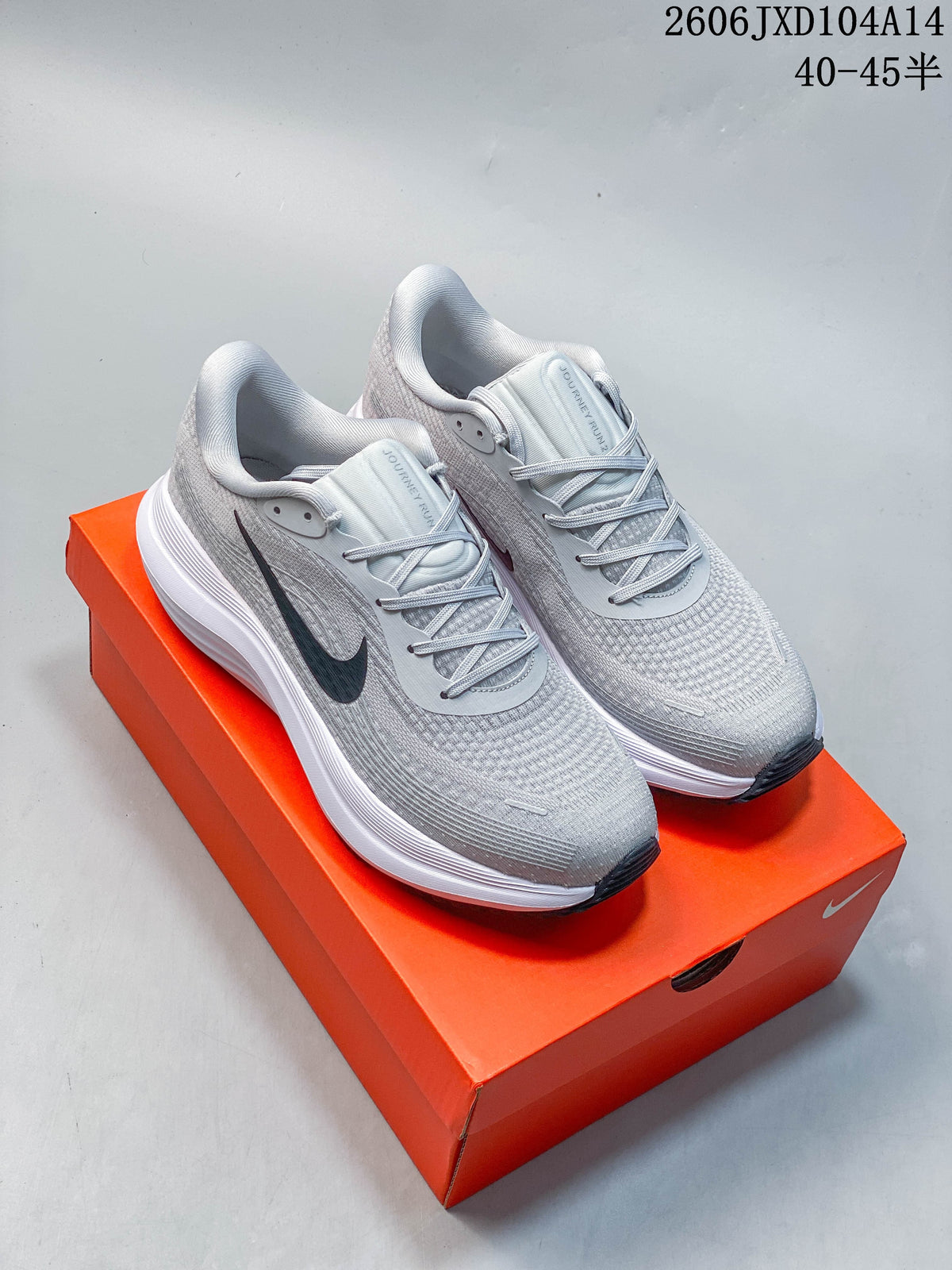 Pair of light gray Nike Journey Run running shoes with dark Swooshes and white midsoles.