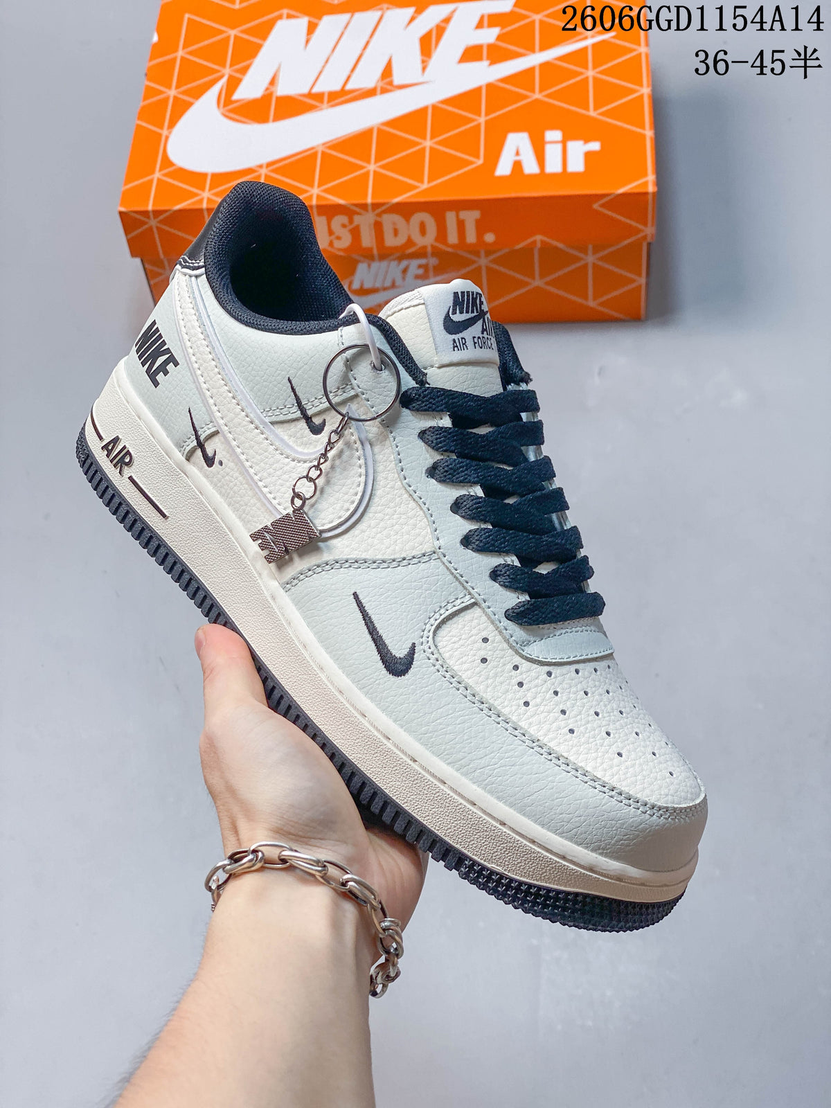 Angled side view of a cream and navy Nike Air Force 1 with decorative hangtag
