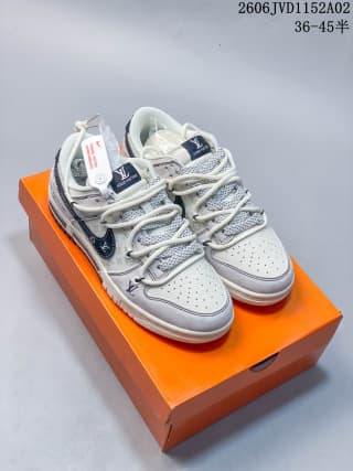 Pair of white and gray low-top sneakers displayed on an orange shoe box, showing the matching design and dark blue accents.