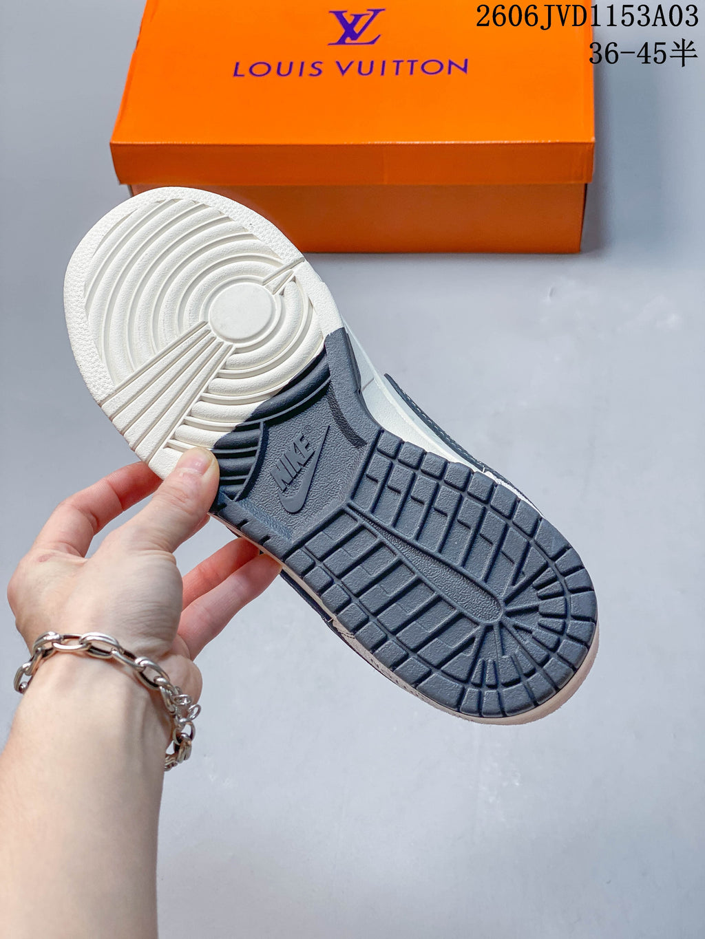 Outsole view of a white and dark grey low-top sneaker