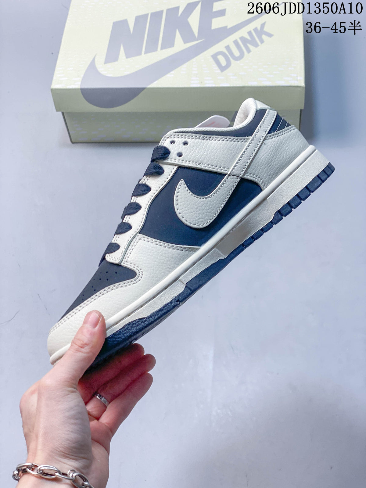 Side view showing navy and off-white panels, a Swoosh, and a low-top profile