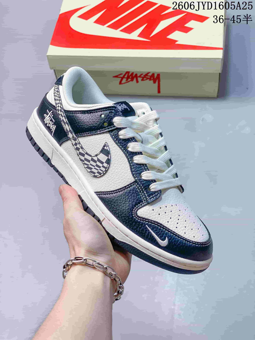 White and dark navy low-top sneaker with a checkerboard side detail and white laces