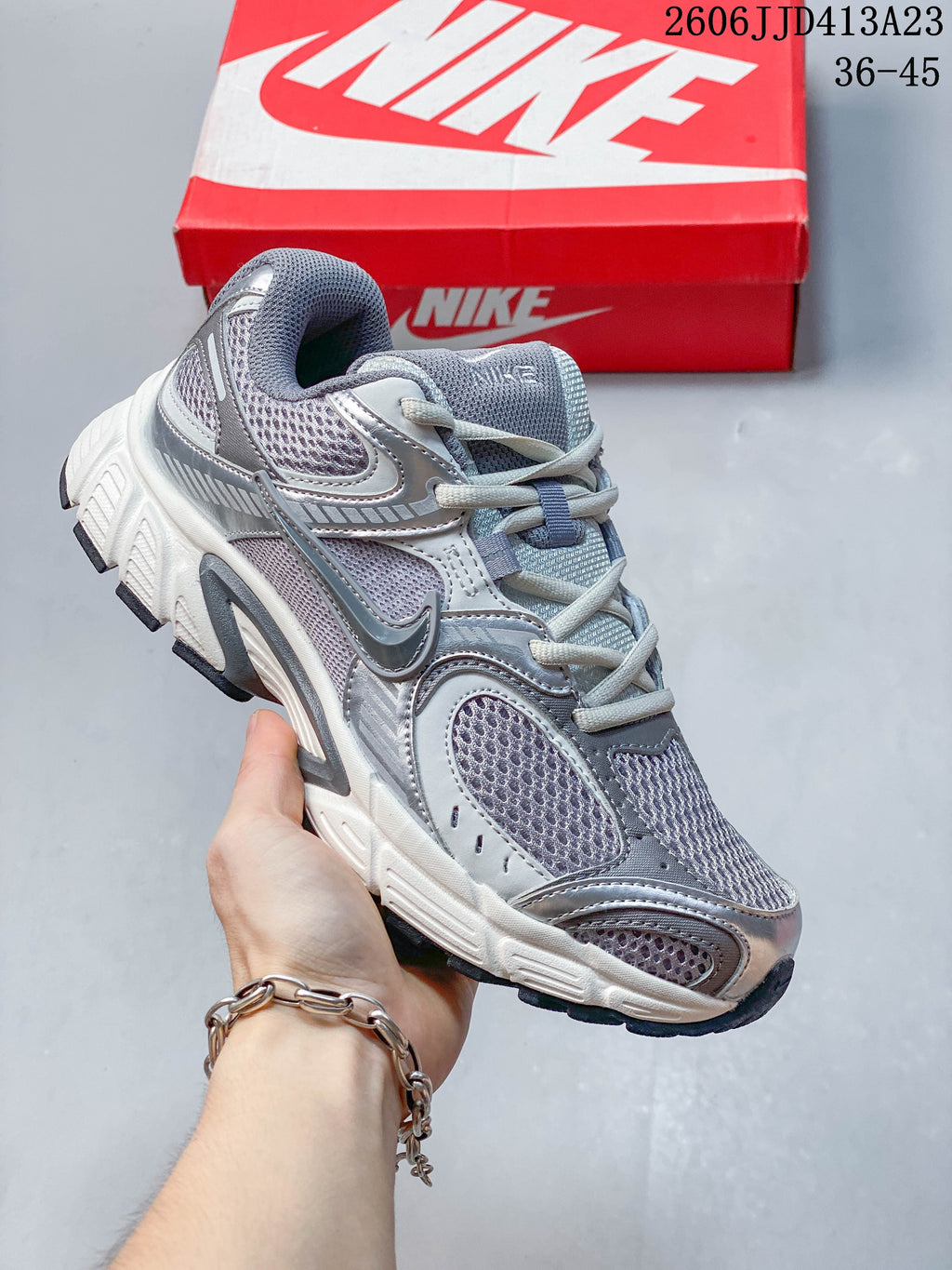 Gray and white Nike Air Zoom Winflo 12 sneaker with mesh panels and a sculpted sole.