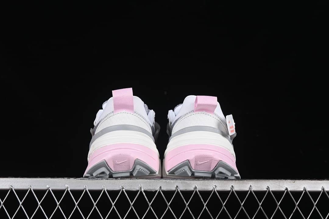 Rear view of both sneakers showing pink heel sections and grey outsole details.