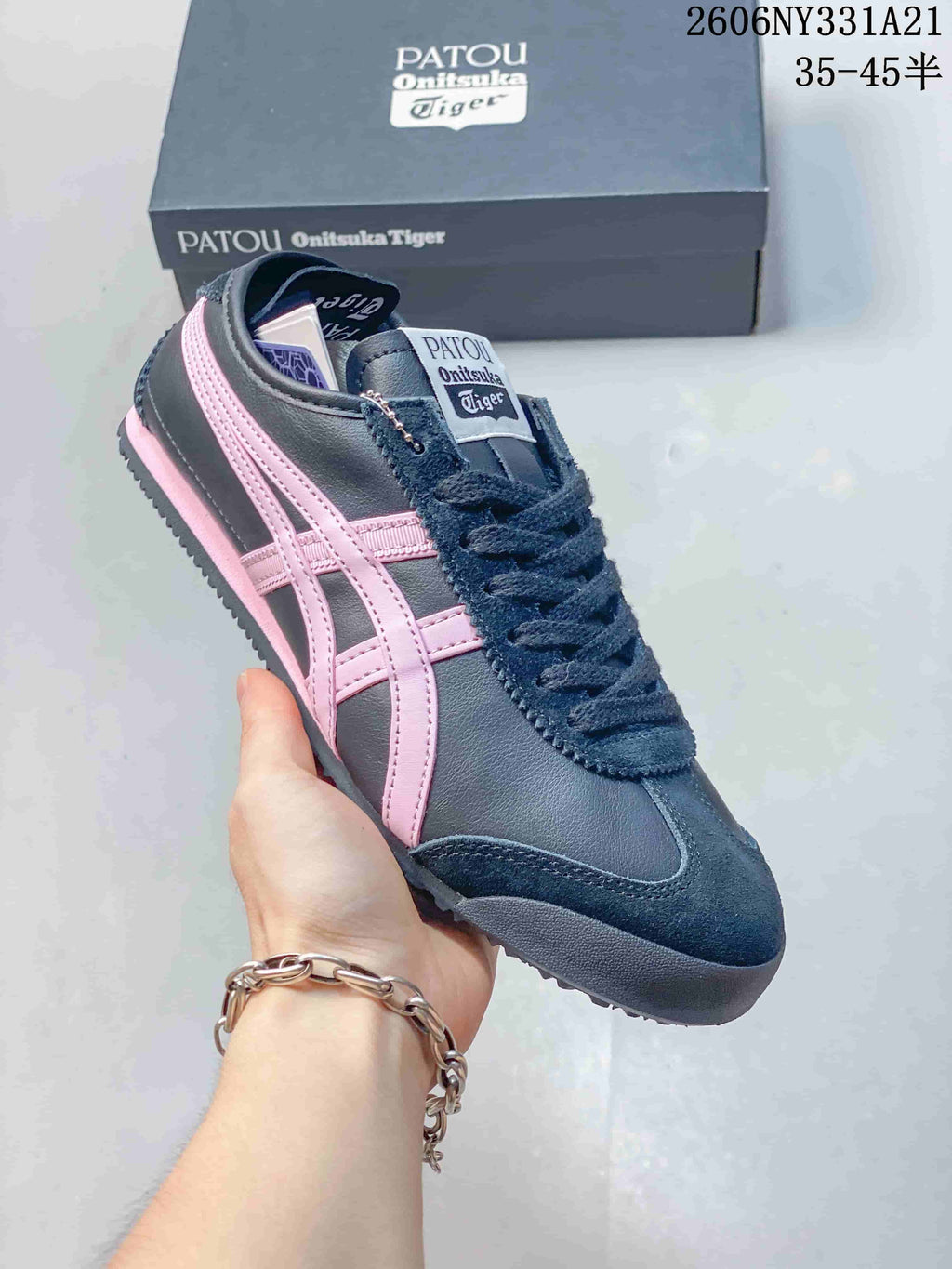 Angled view of the navy sneaker with pink side stripes and branded tongue label