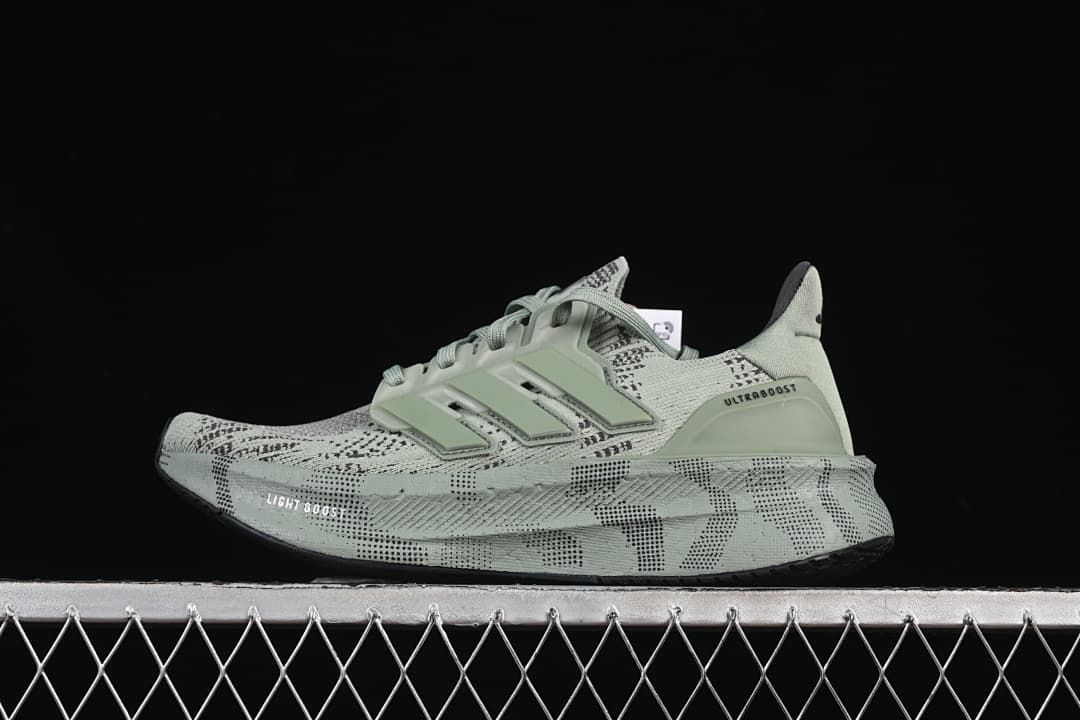 Side view of pale sage-green Adidas Ultraboost 5 running shoe with patterned upper