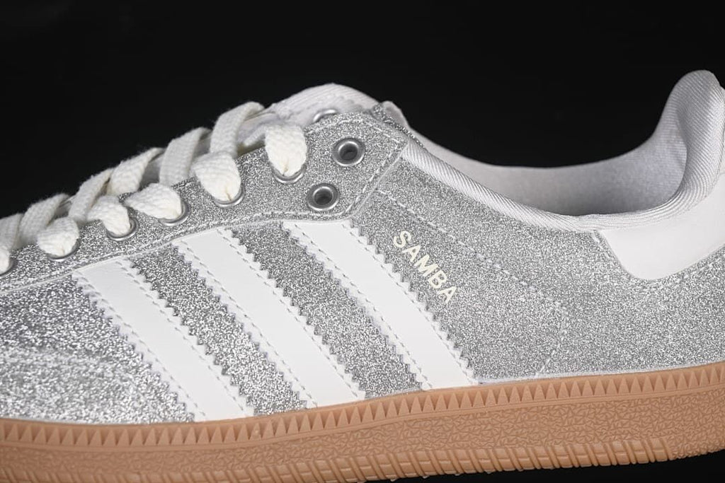 Close-up of the silver glitter-effect upper, white stripes, laces and gum-colored sole.