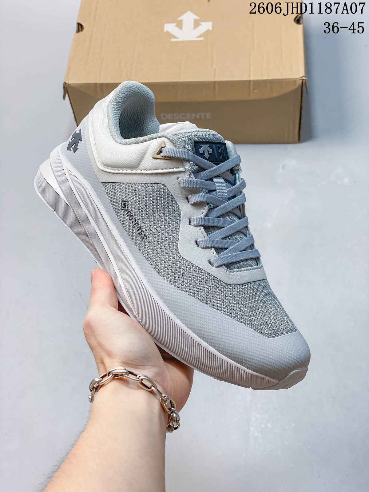Angled side view of the gray and white sneaker with visible brand markings.