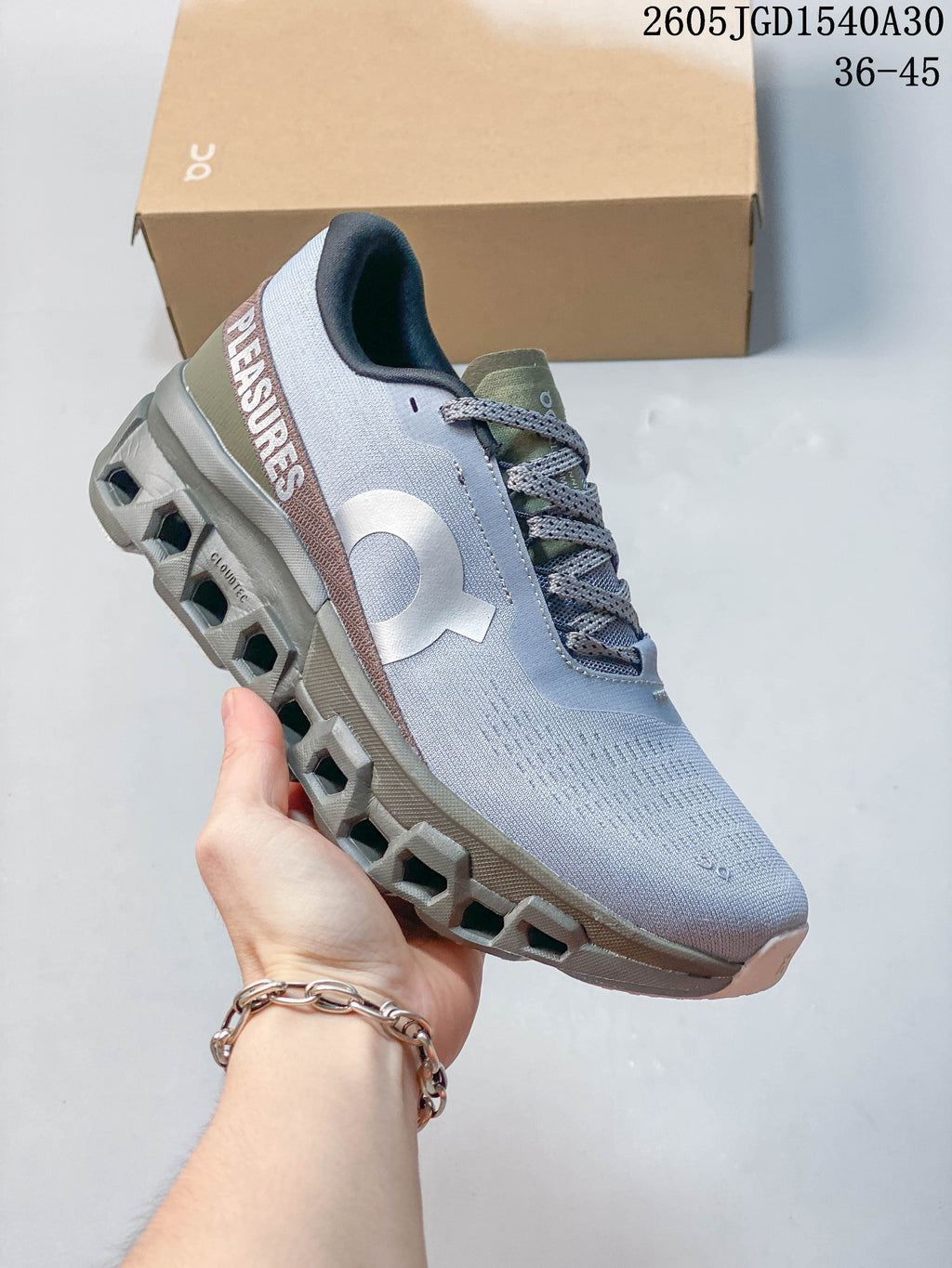 Side view of the gray sneaker showing On branding and heel lettering