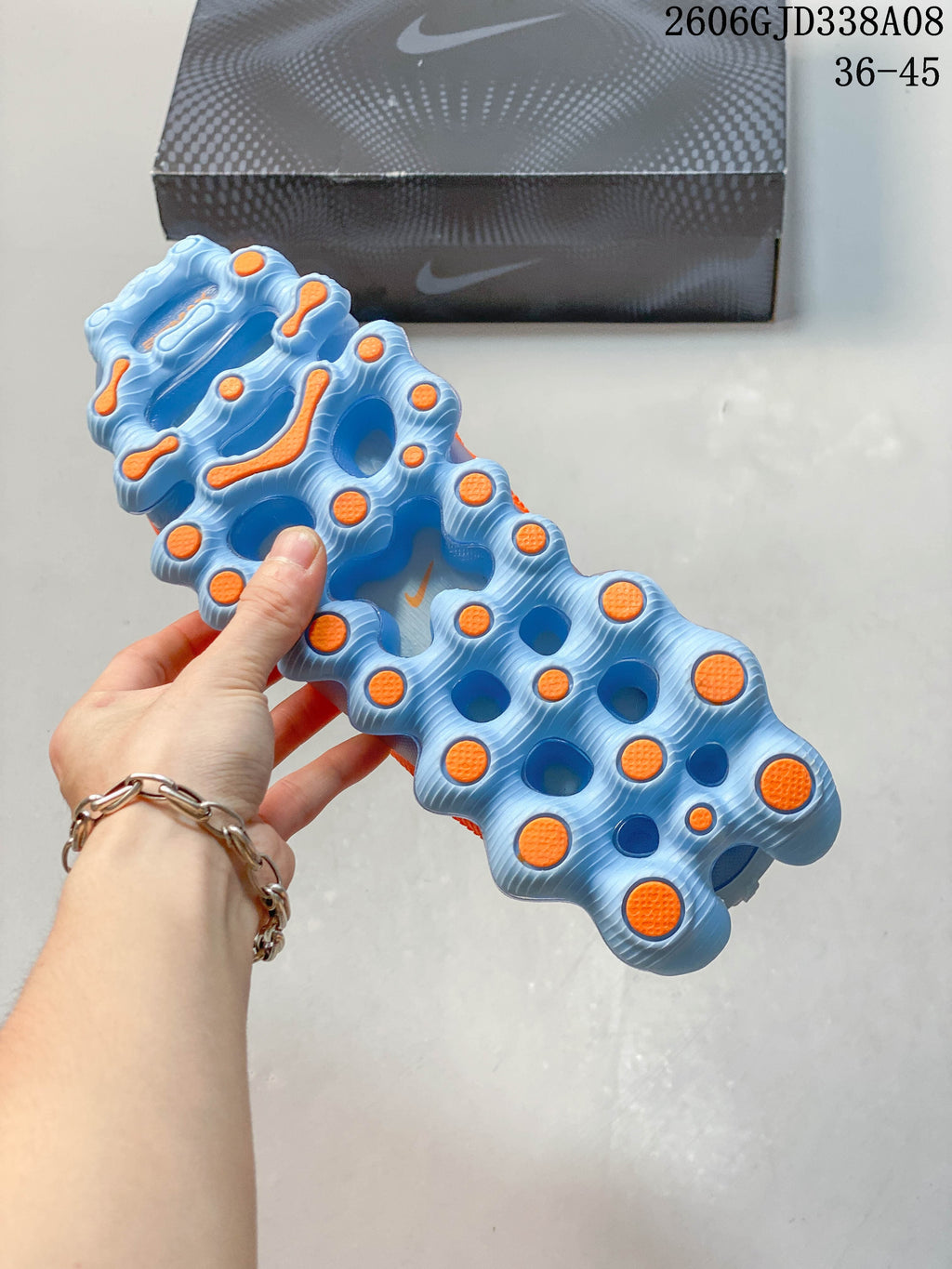 Underside of a shoe showing a sculpted blue sole with orange traction details.
