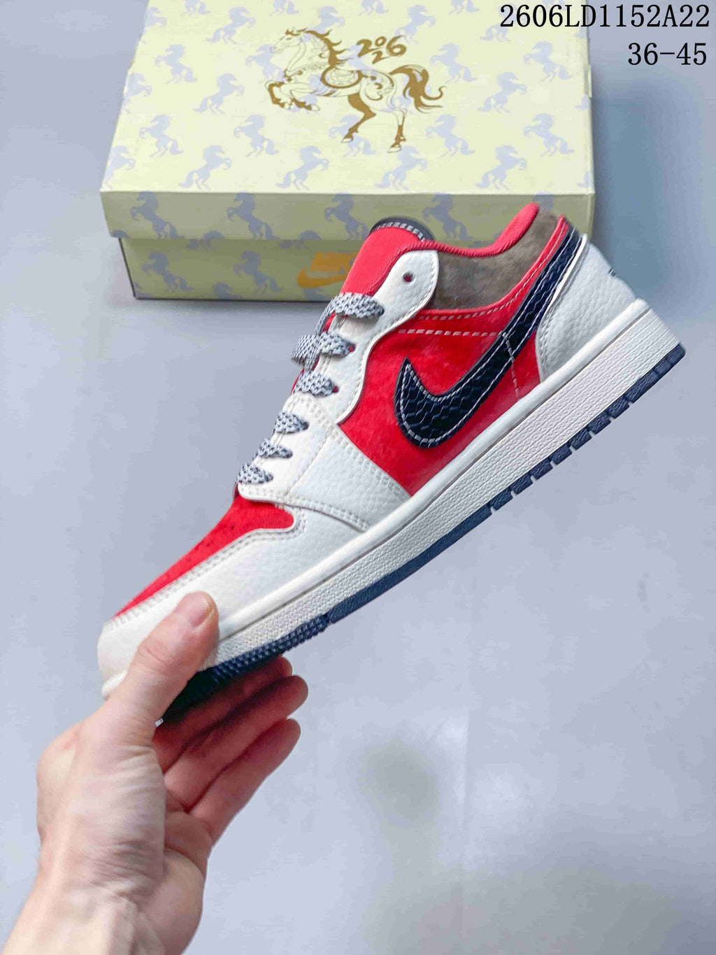 Side view of a red and white low-top Jordan sneaker with a dark navy accent
