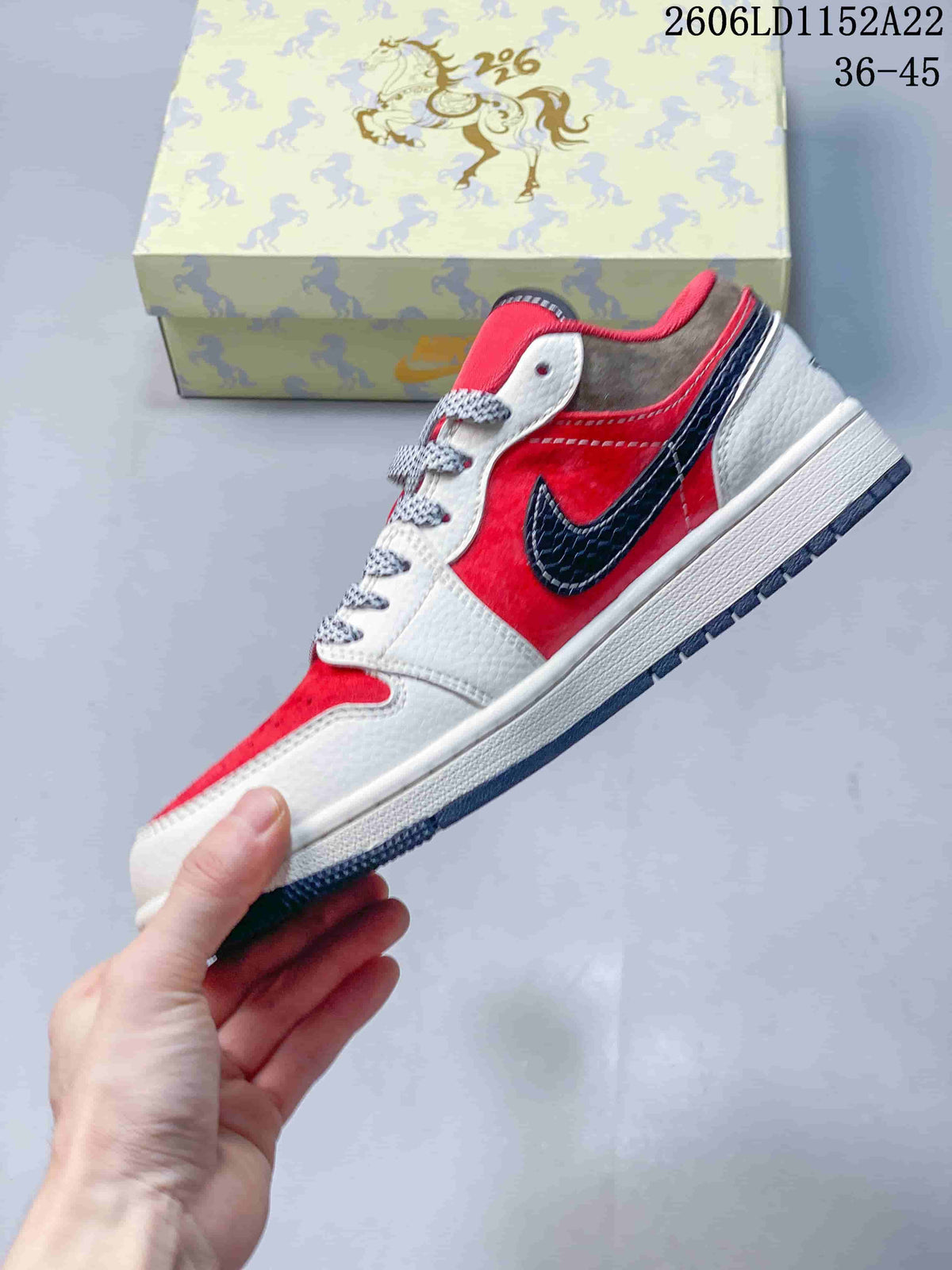 Side view of a red and white low-top Jordan sneaker with a dark navy accent
