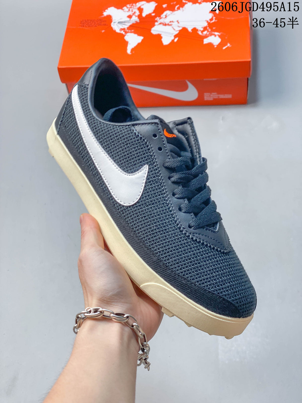 Angled side view of a dark navy Nike Astro Grabber sneaker with a light-colored Swoosh and cream sole.