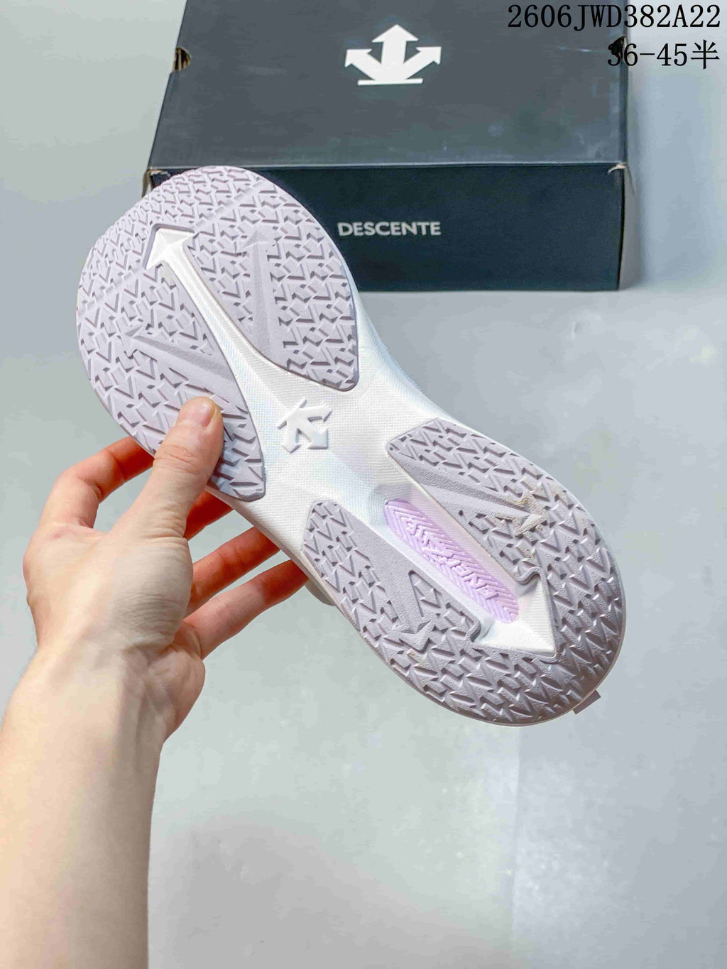 Close-up of the patterned outsole on the white and lavender DESCENTE running sneaker