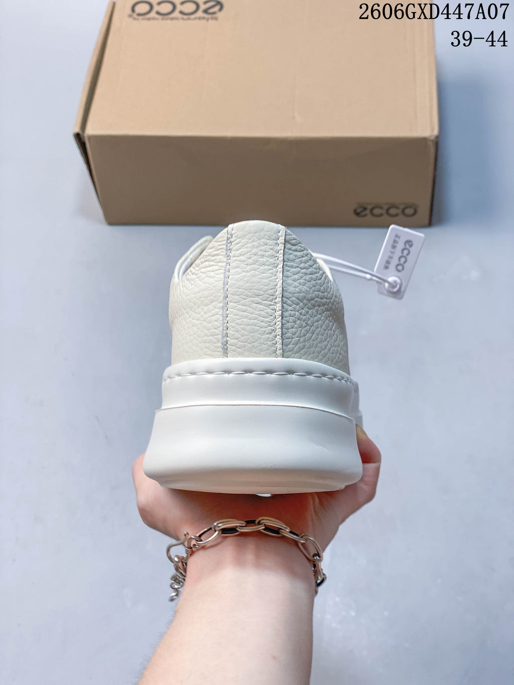 Rear view of the white sneaker showing the heel and thick sole
