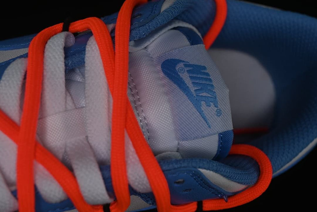 Close-up of the tongue, white laces, and orange-red overlay laces.