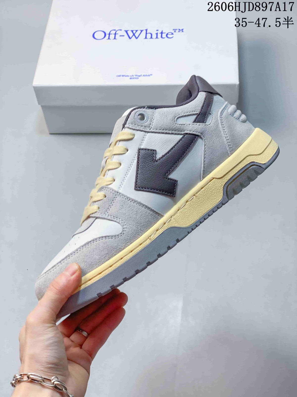 Side view of the white and grey sneaker with a dark arrow-shaped detail