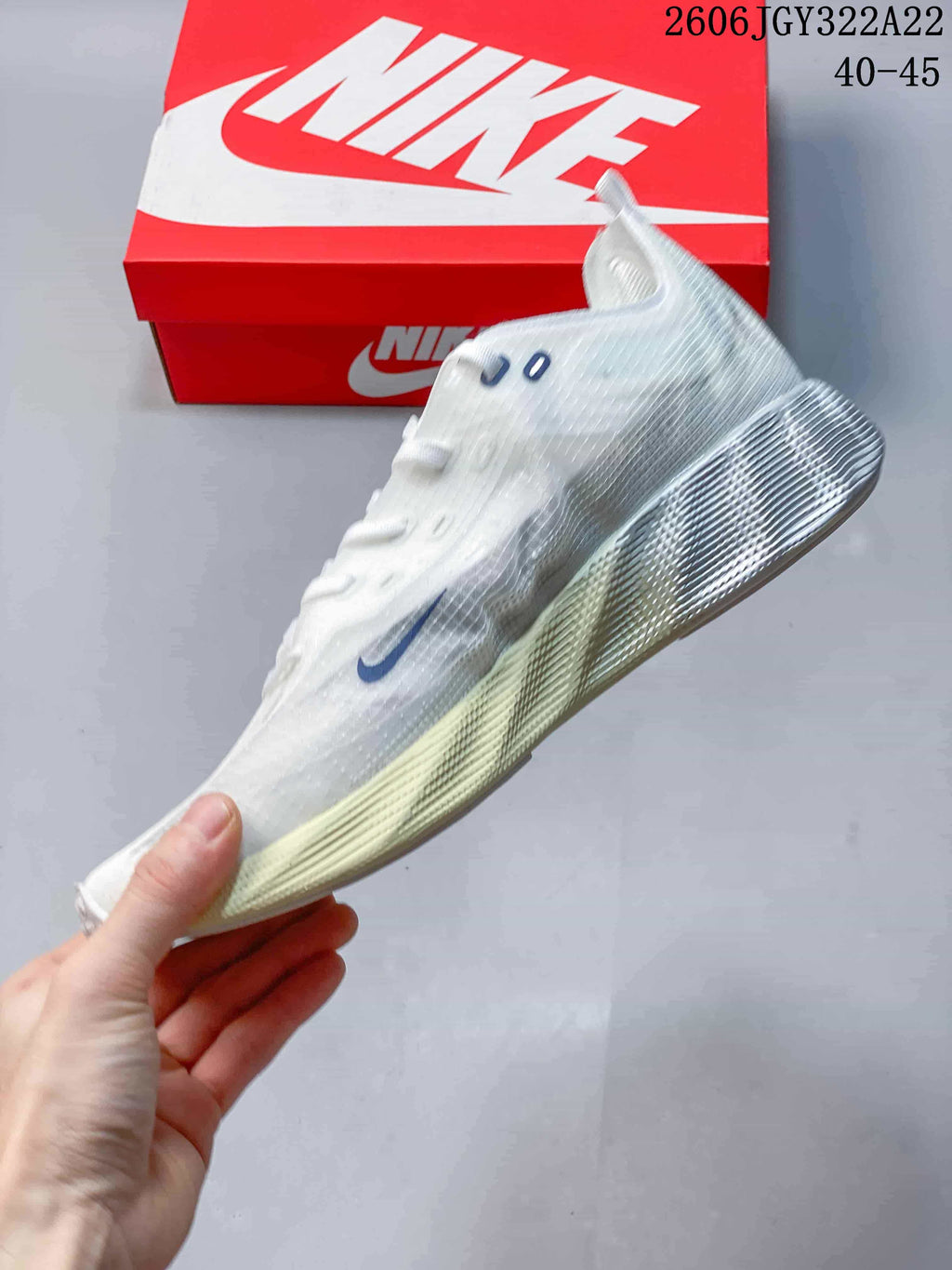 Side profile of a white Nike Ava X low-top shoe with blue Swoosh and sculpted sole.