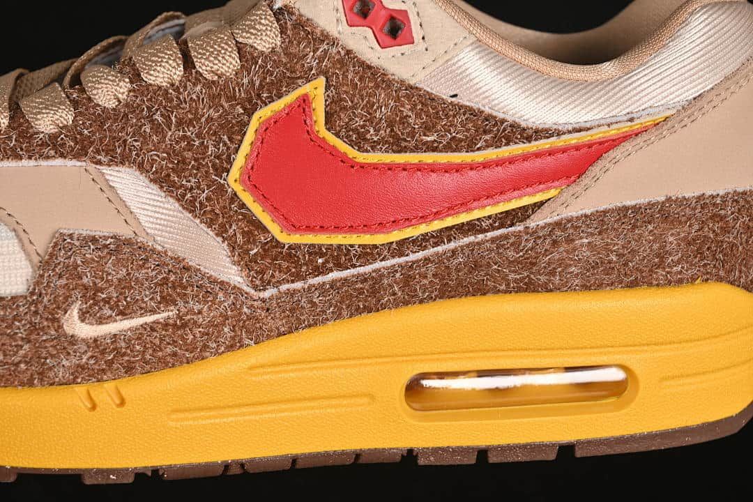 Close-up of the red side Swoosh with yellow trim, brown upper, and visible midsole Air unit.