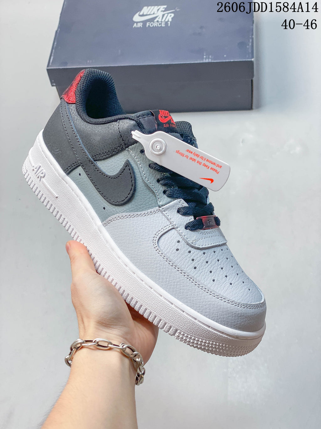 Angled view of the sneaker showing its white and grey panels and dark Swoosh