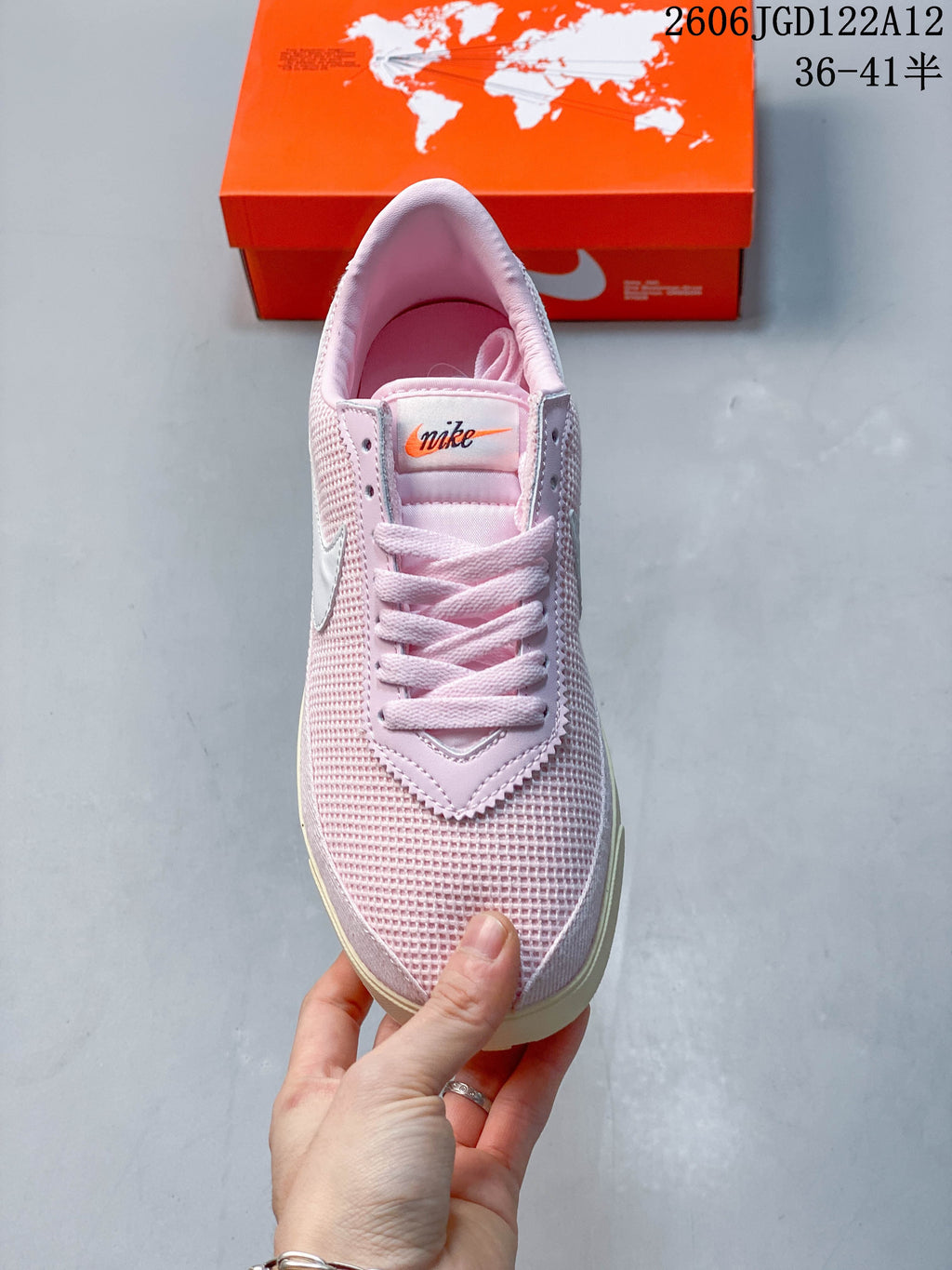 Top view of the pink lace-up sneaker with white swoosh details
