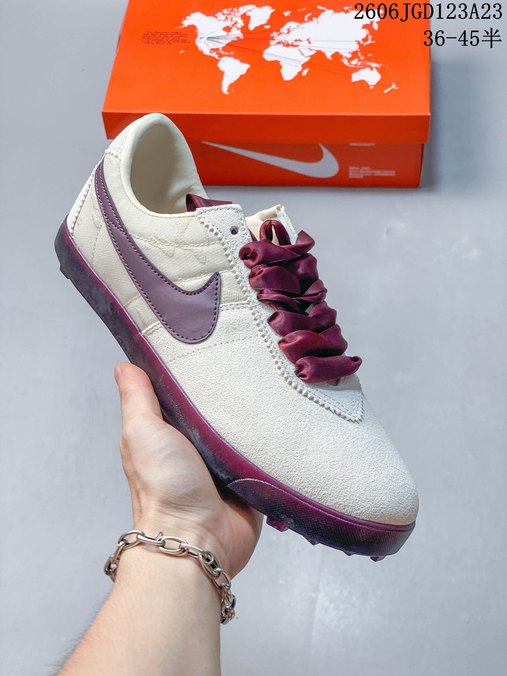 Angled side view of the off-white low-top sneaker with a plum Swoosh and wide laces