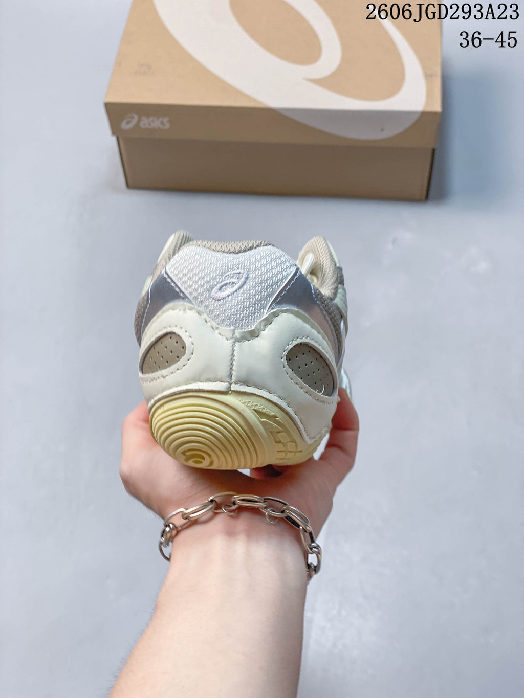 Rear view of the cream sneaker showing heel paneling and outsole