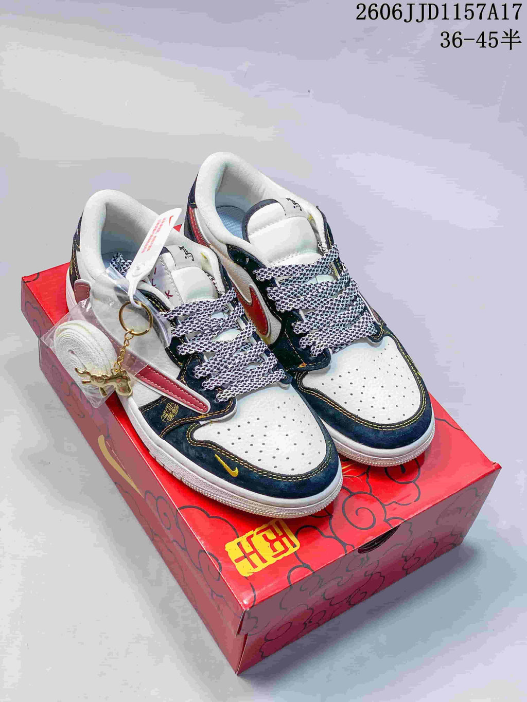 White low-top sneakers with dark navy overlays, red accents, and patterned laces.