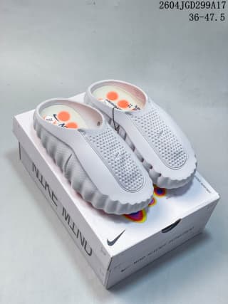 Pair of white Nike Mind slides displayed on a Nike Mind shoe box.