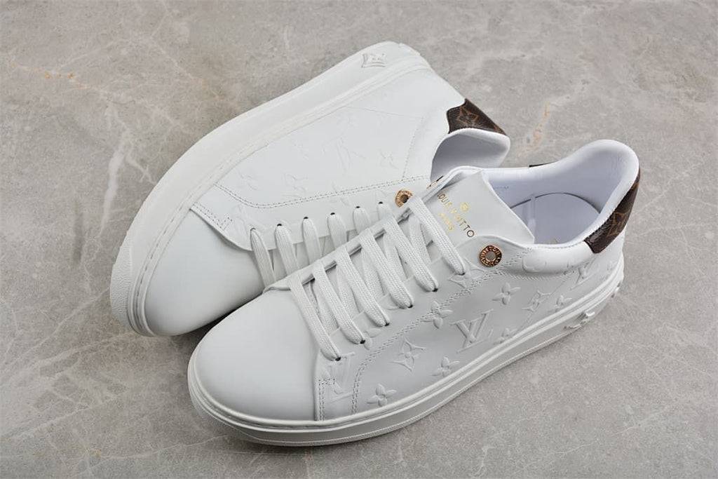 Pair of white low-top platform sneakers with embossed uppers and brown heel panels