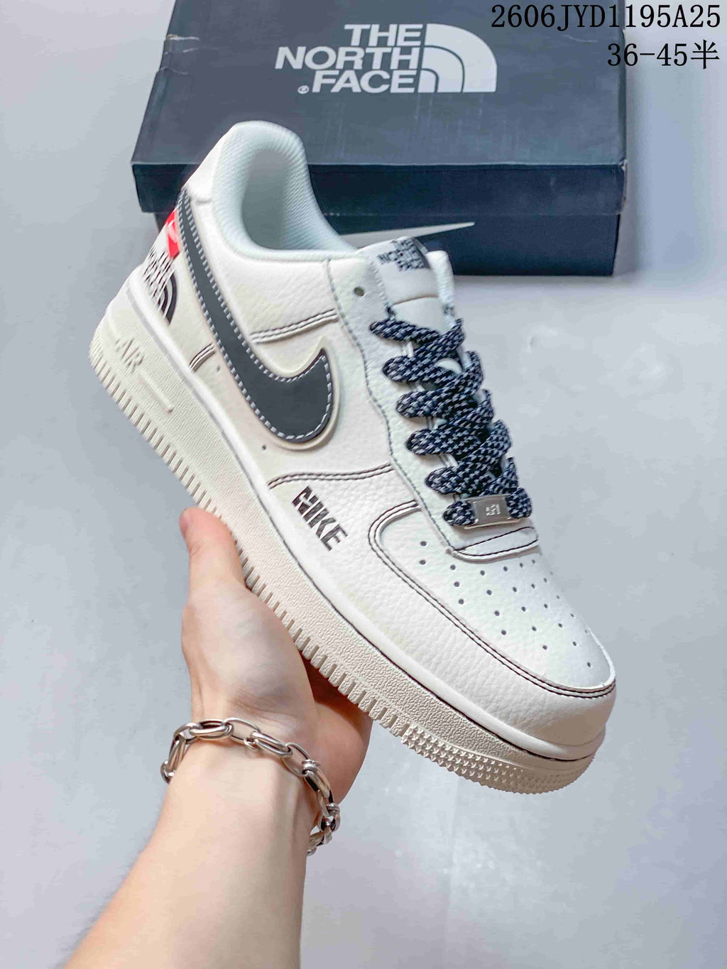 Close view of a white low-top sneaker with dark Swoosh and patterned laces
