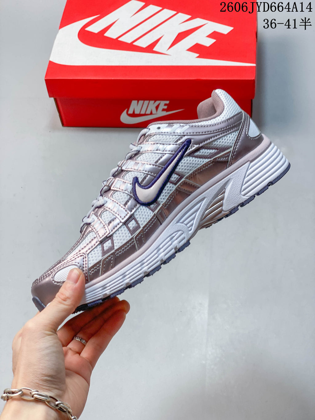Side view showing the layered silver upper and purple Nike Swoosh