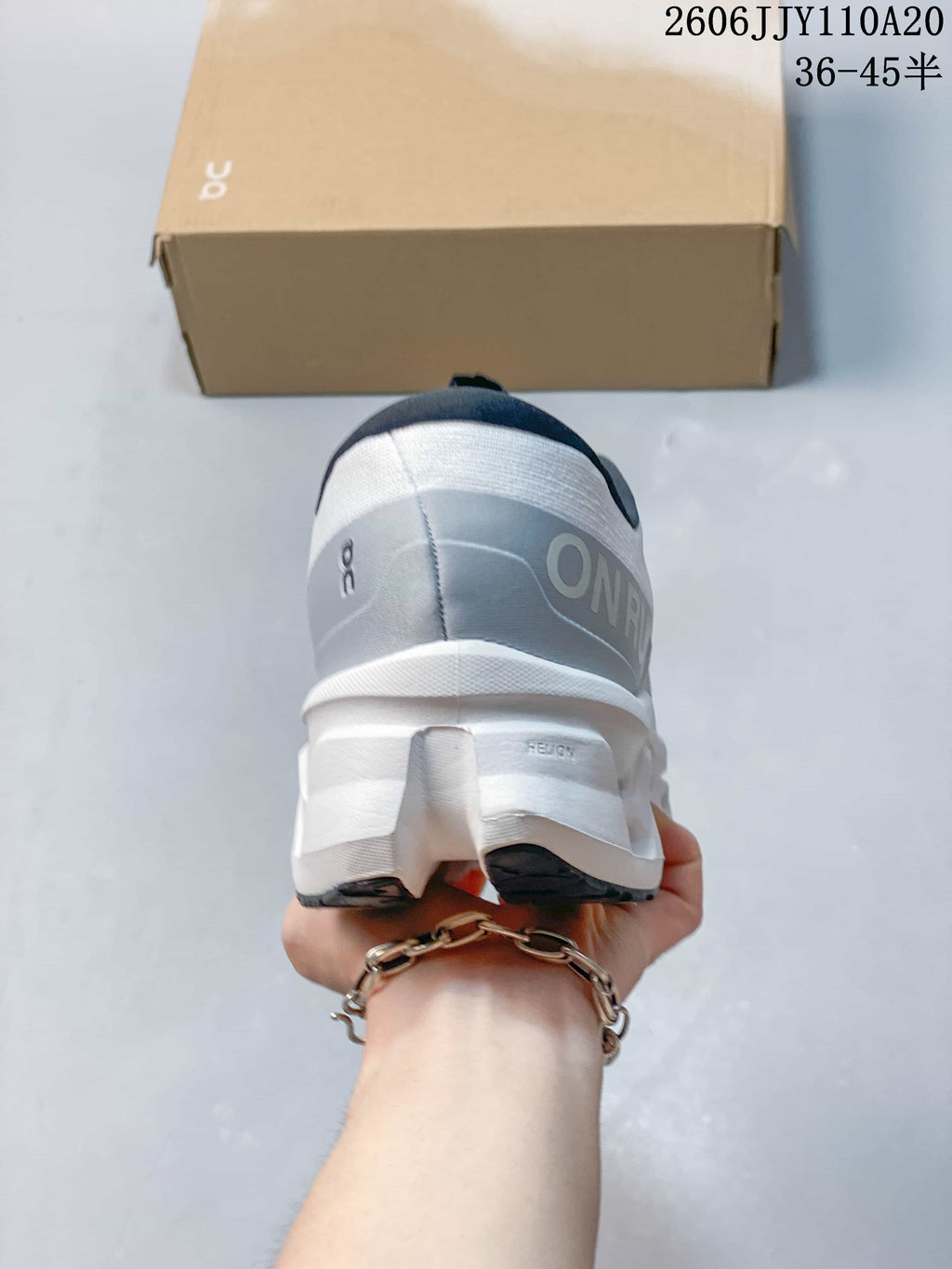 Rear view of the white On Cloudmonster 3 shoe with gray heel panel