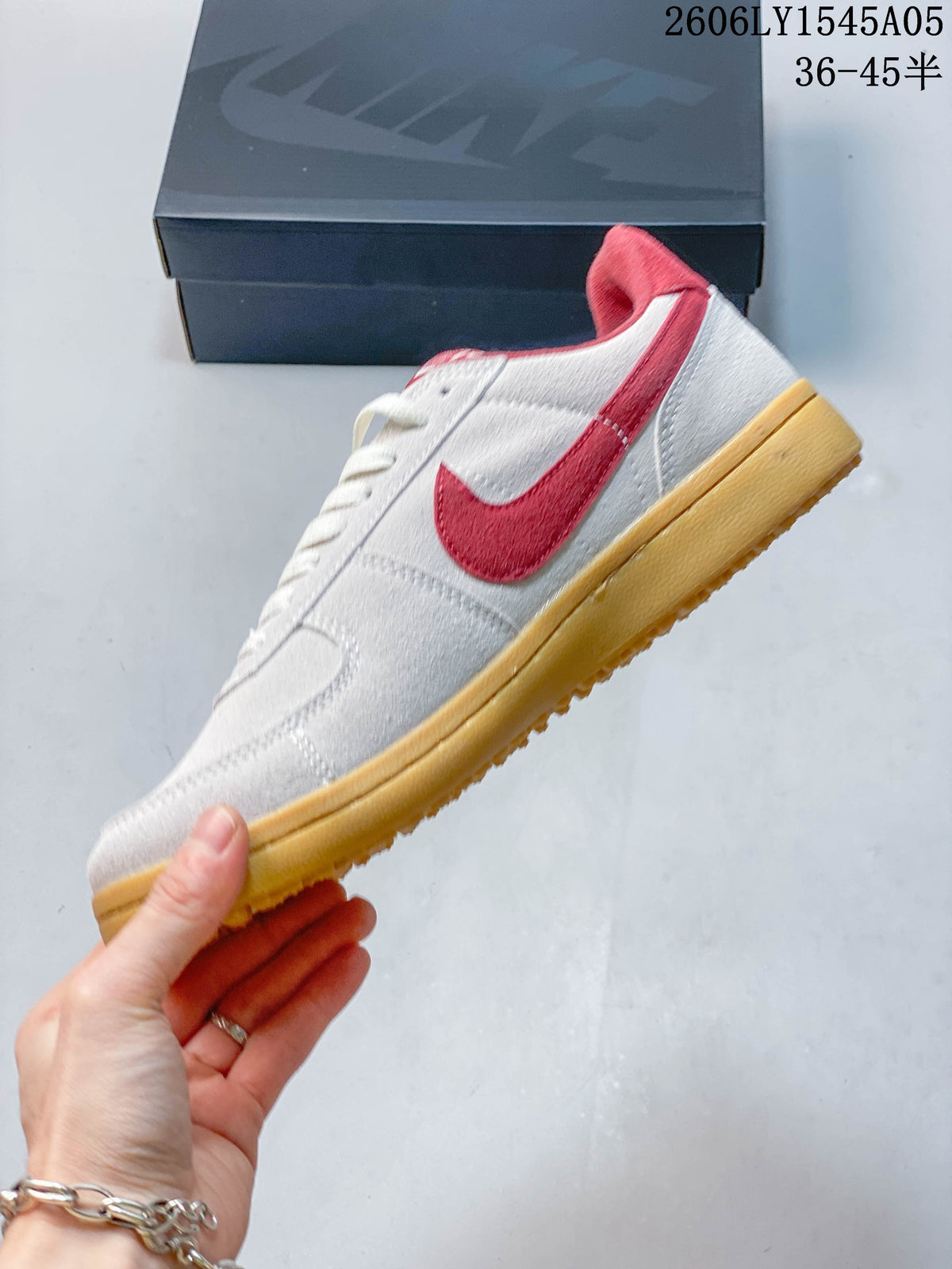 Side view of the white and red low-top sneaker with a gum-colored sole