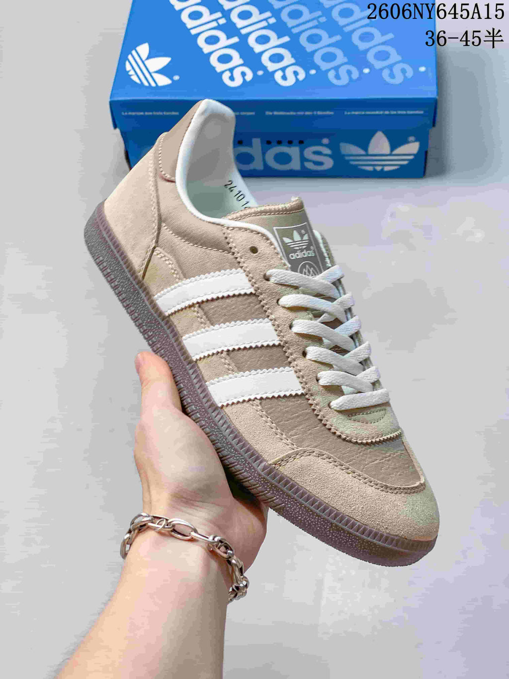 Side view of a beige adidas Handball Spezial sneaker with white stripes, laces, and a gum-style sole.