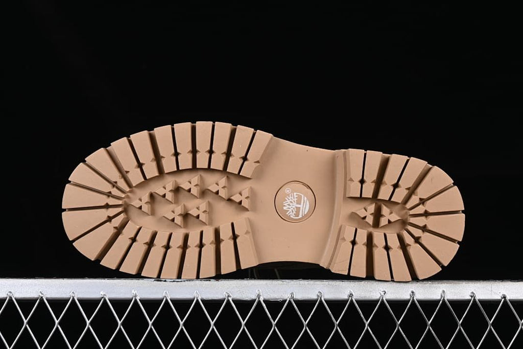 Underside view showing the boots' grooved tan outsoles.