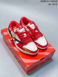 Pair of red, white, and navy low-top sneakers with decorative charms on a patterned box